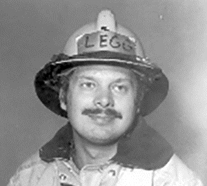 Charles is wearing his Columbus Fire coat and fire helmet as he posing for his recruit photo identification in April of 1980. 