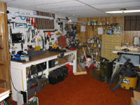 A large workbench for performing mechanical repairs and assembly including a wide range of power tools including a table saw and shop vacuum. 
